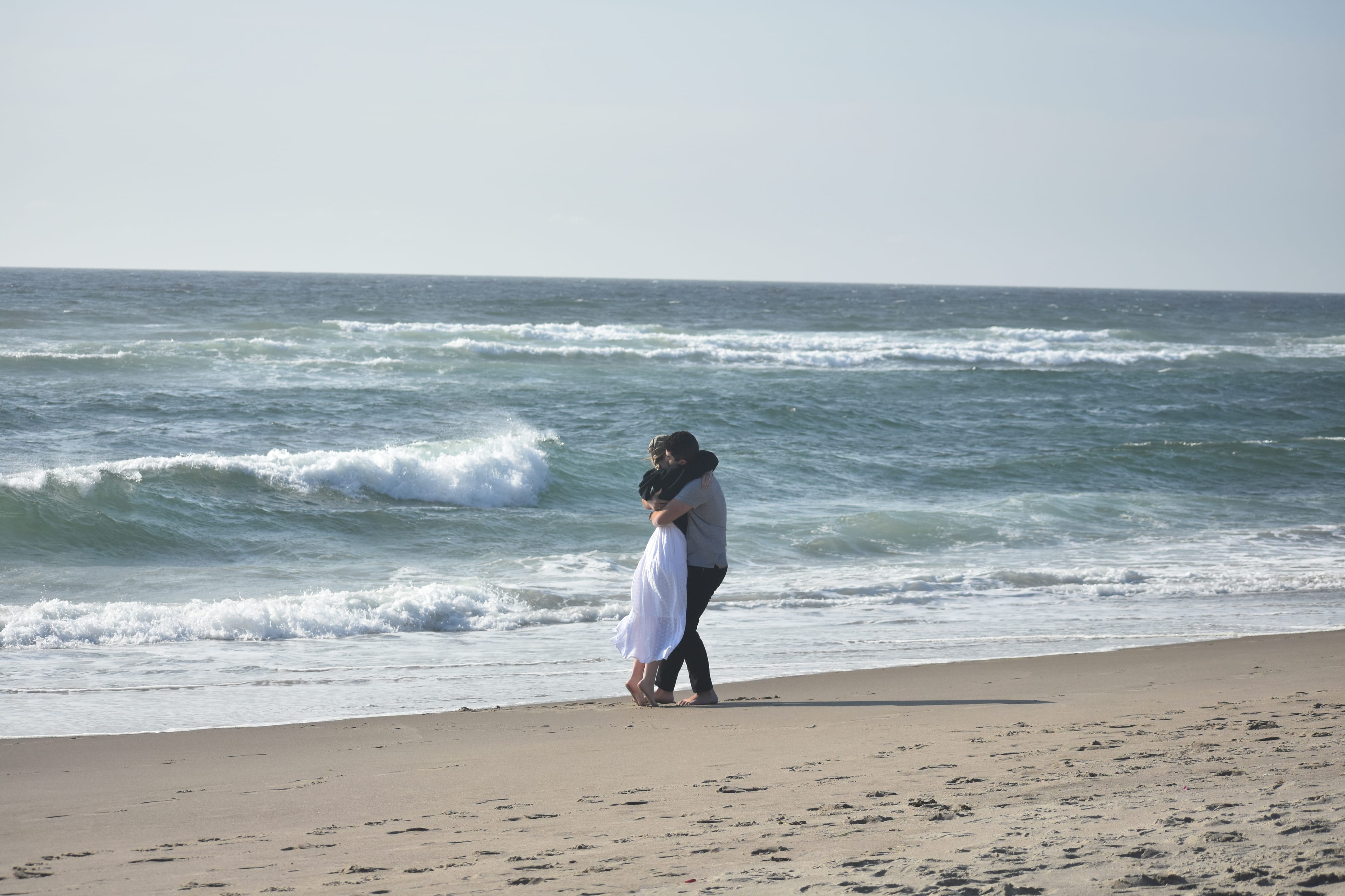 Johanna and Andrew embracing by the ocean